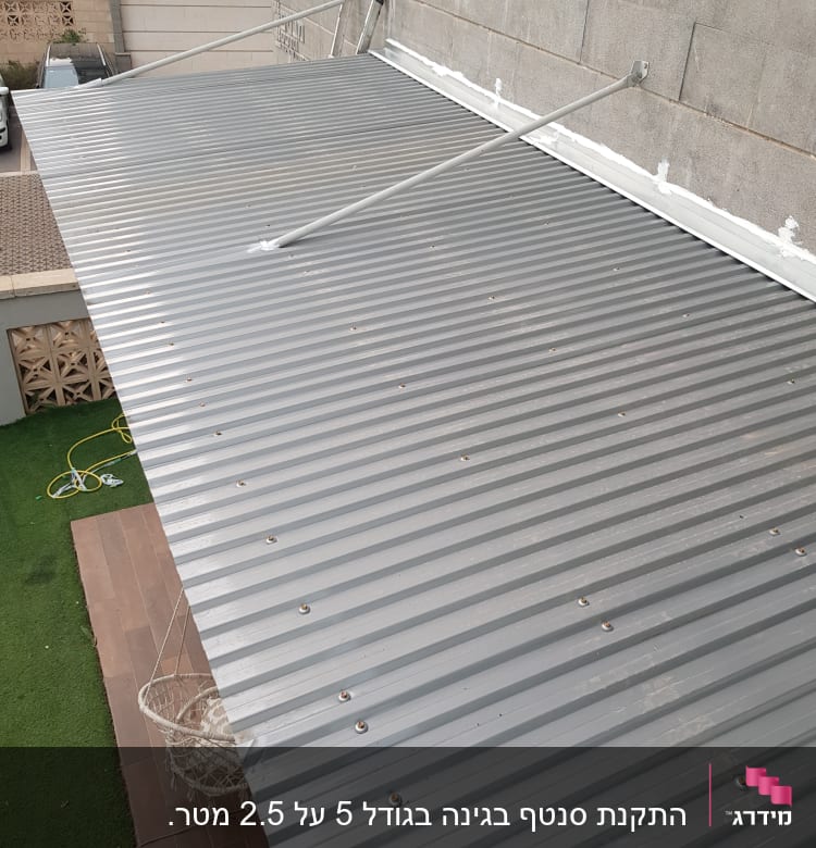 גג מתכת מחובר לקיר עם מוטות תמיכה
